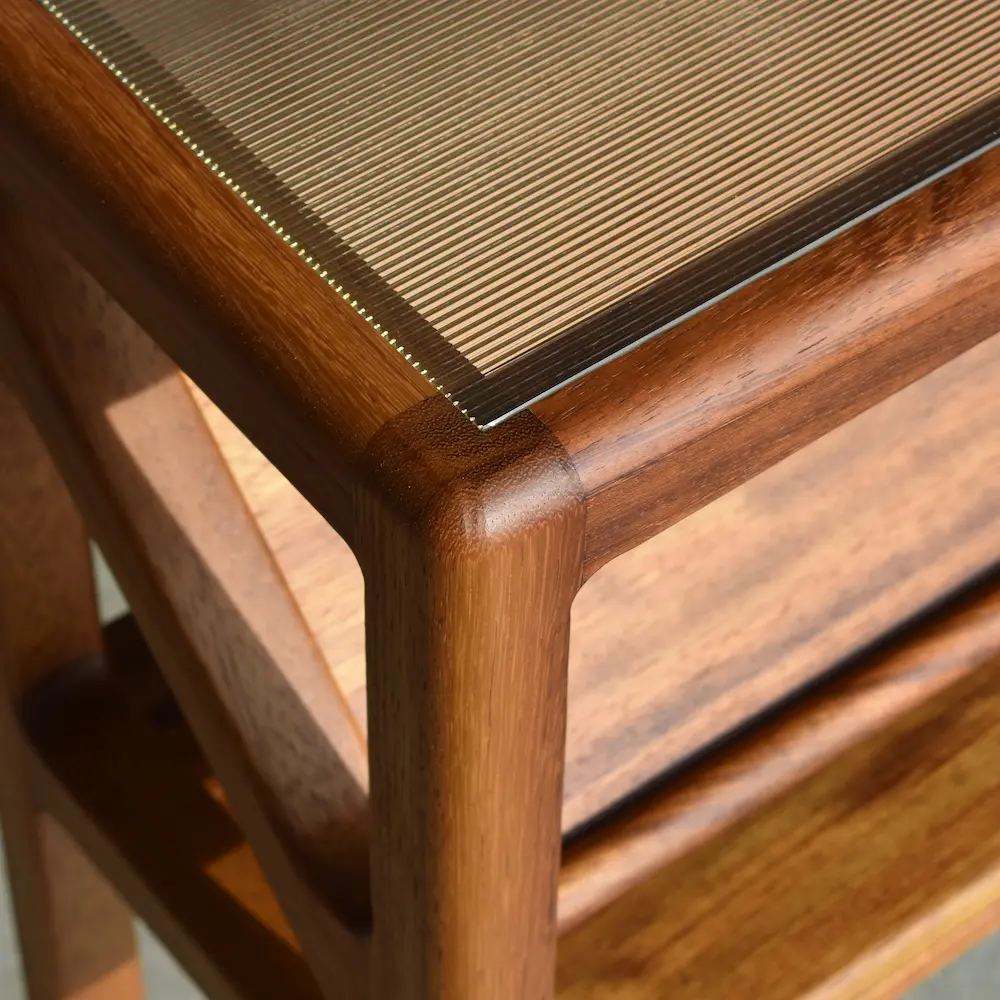Hoekdetail van retro dressoir met ribbel structuurglas en houten frame in iroko hout